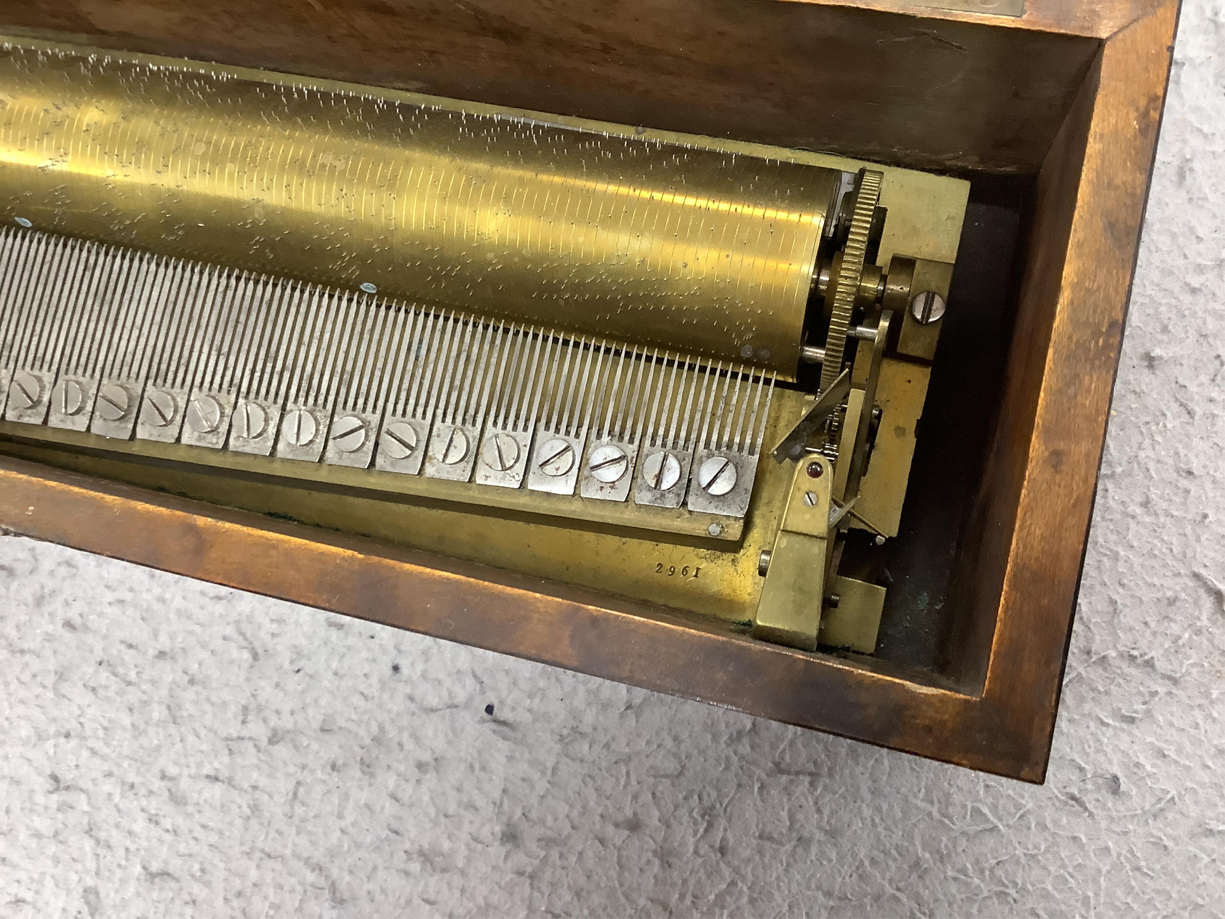 A small mid 19th century Swiss musical box in a bird’s eye maple case, side key wound, 30cm wide. Condition - fair.